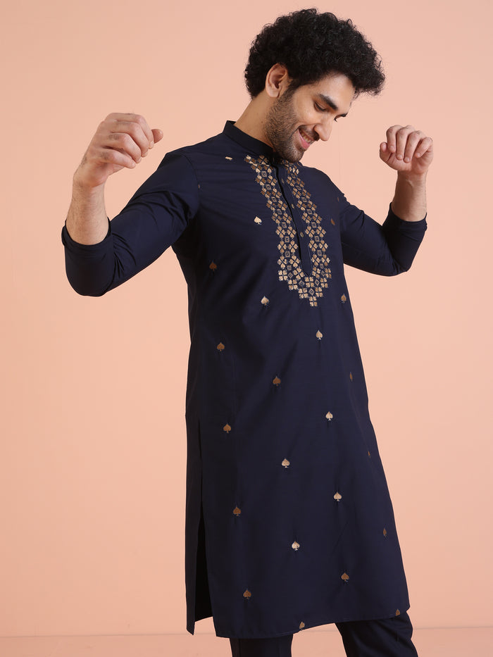 The model is captured in a playful pose, wearing Kisah Men’s Navy Blue Embroidered Kurta Set with raised hands