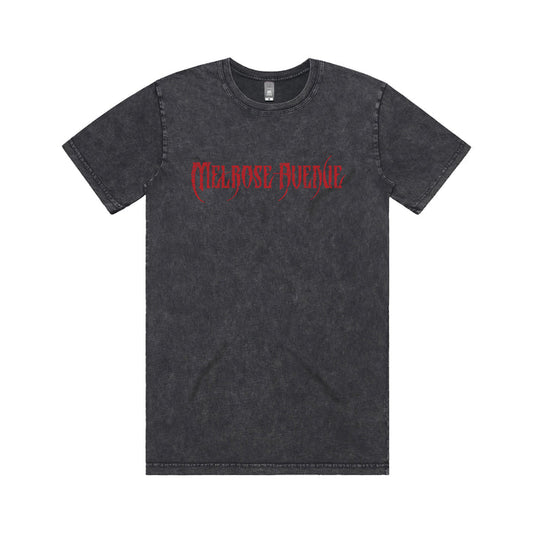 A black acid-wash tee from Melrose Avenue, featuring “Melrose Avenue” in red gothic font across the chest, displayed on a white background.