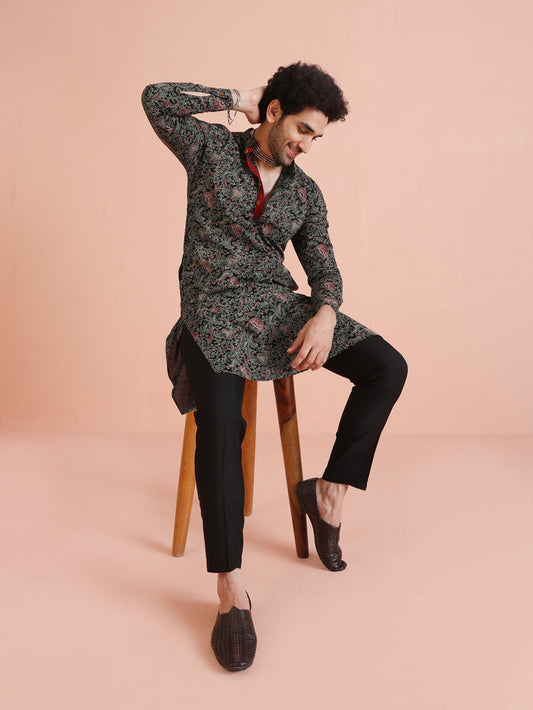 The model is seated on a chair while wearing Black Printed Cotton Silk Kurta Trouser Set of Kisah.