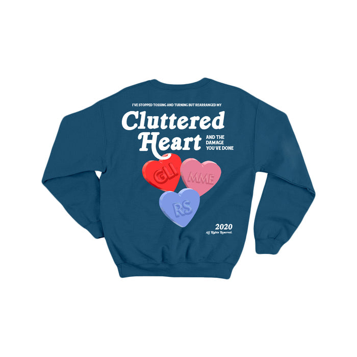 Blue glimmers sweatshirt featuring Cluttered Heart text surrounded by candy hearts labeled GUILT, MME, and RS, with extra text and the year 2020 on the lower right side.