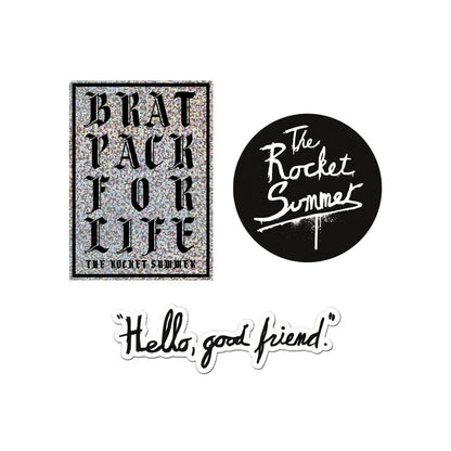 Three The Rocket Summer stickers: a glittery BRAT PACK FOR LIFE THE ROCKET SUMMER Brat Pack sticker, a round black logo sticker with white script, and a playful Hello Good Friend sticker in black cursive.