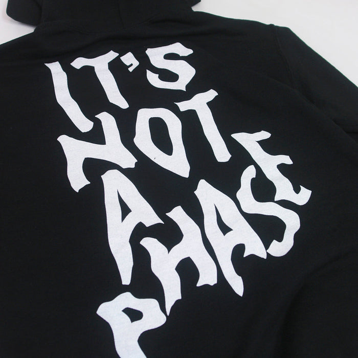 A Phase Black hoodie from Stay Sick Clothing with bold, white, stylized text on the back that reads “ITS NOT A PHASE.”.