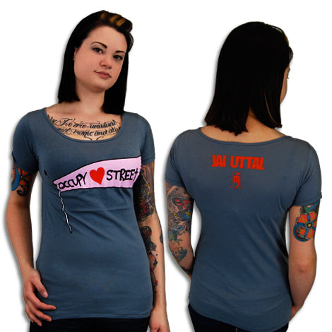 A woman with tattoos models a gray Mantralogy T-shirt, shown front and back. The front has a pink and white OCCUPY ♥ STREET graphic. The back features red JAI UTTAL text with a small symbol underneath.