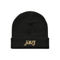 A black beanie hat by Joey Fleming featuring joey embroidered in gold lettering on the front fold.