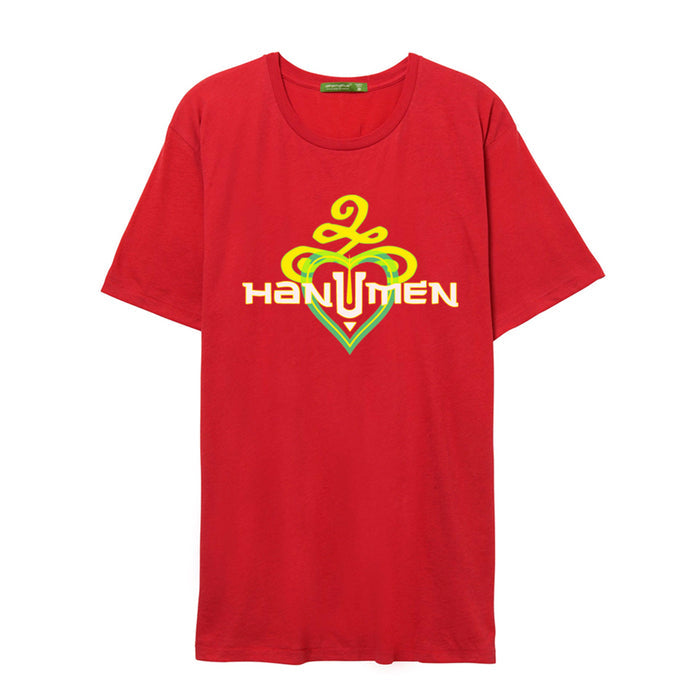 A red T-shirt by The Hanumen features a yellow and green abstract design above HANUMEN in bold white letters with yellow outlines, set over a stylized heart in red, green, and yellow.