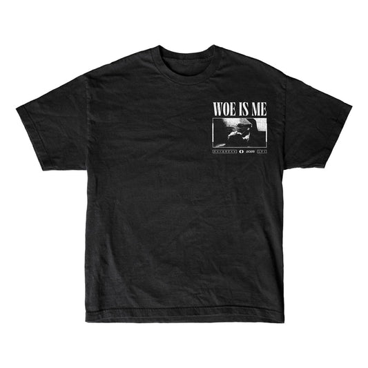 Woe Is Me black t-shirt featuring a small chest graphic of a seated person with WOE IS ME above, referencing LP3. Includes extra white text and design details beneath the image.