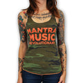 A woman with colorful tattoos on her arms and chest wears a camouflage tank top featuring bold orange MANTRA MUSIC REVOLUTIONARY text by Mantralogy. The image is cropped at her neck and waist.