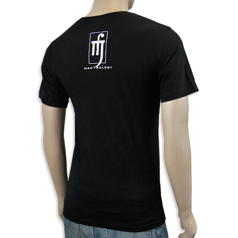 A person is shown from behind wearing a black Mantralogy short-sleeve t-shirt featuring a white rectangular logo and MAN TRILOGY text on the upper back, paired with light blue jeans.