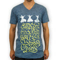 A person wearing a blue Mantralogy V-neck T-shirt with three white whirling dervishes above the phrase “dance when you’re broken open” in decorative yellow script.