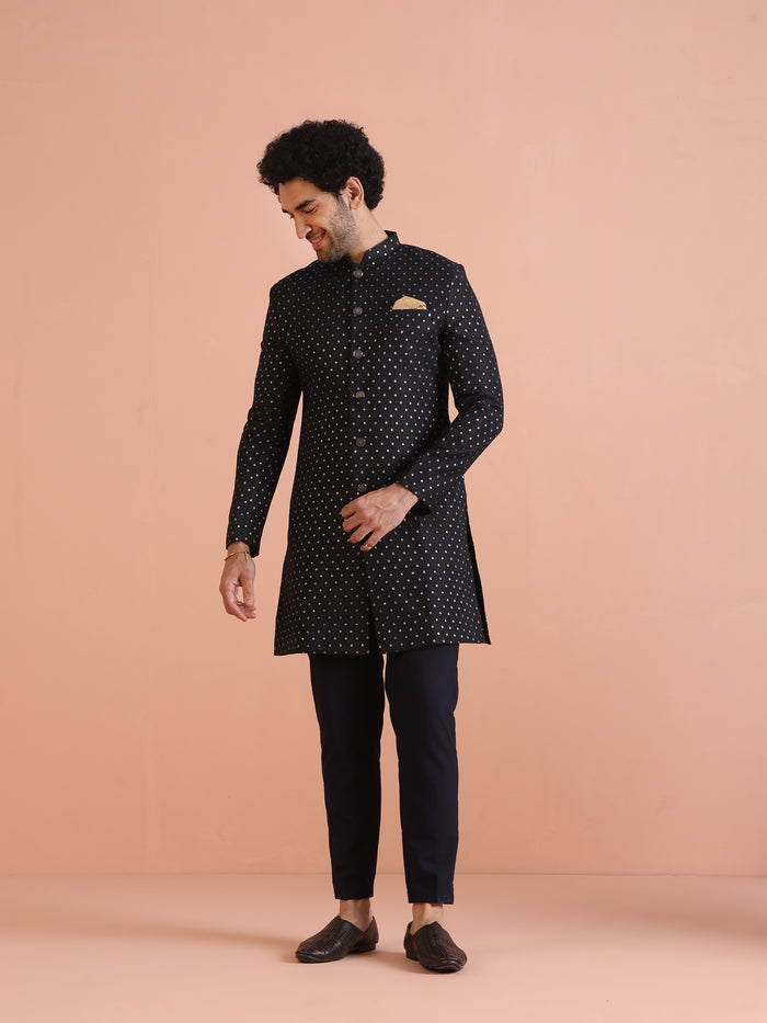 The man is looking downward, posing with Men Navy Blue Embellished Indowestern Trouser Set
