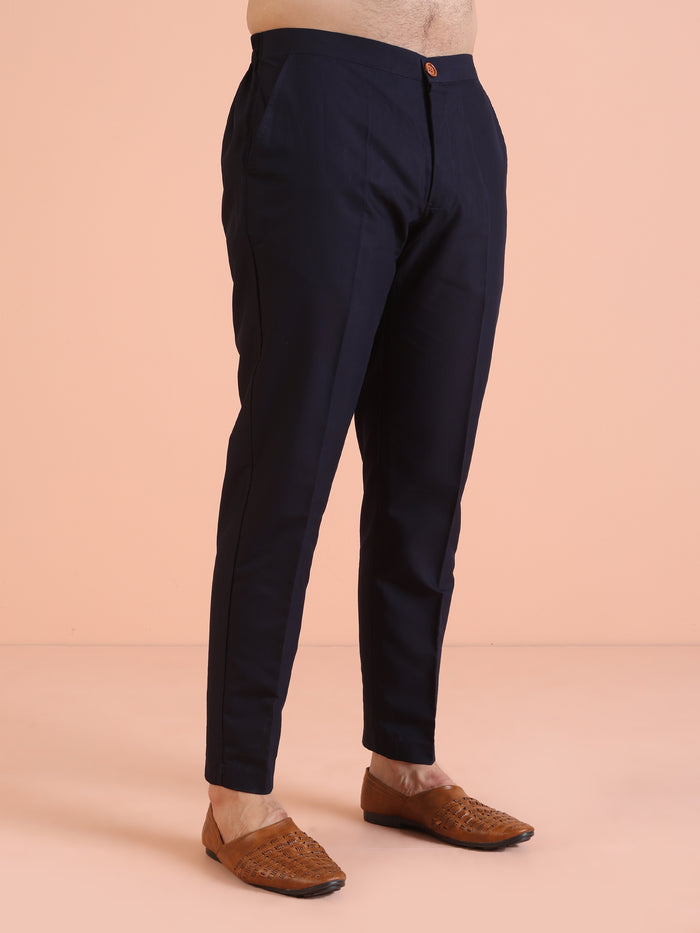 The image focuses on the navy trousers paired with Kisah Men’s Navy Blue Embroidered Kurta Set and brown loafers