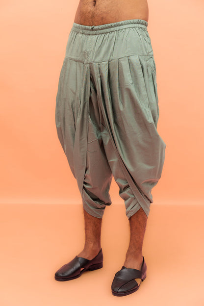 The image focuses on the sage green dhoti with pleated fit, styled with black loafers