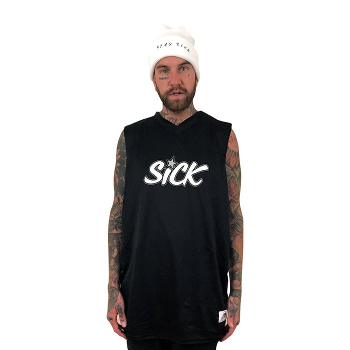 A tattooed, bearded man models edgy streetwear from Stay Sick Clothing: a white beanie with “STAY SICK” and a sleeveless black tee with “SICK” in bold on the front, all set against a plain white background.