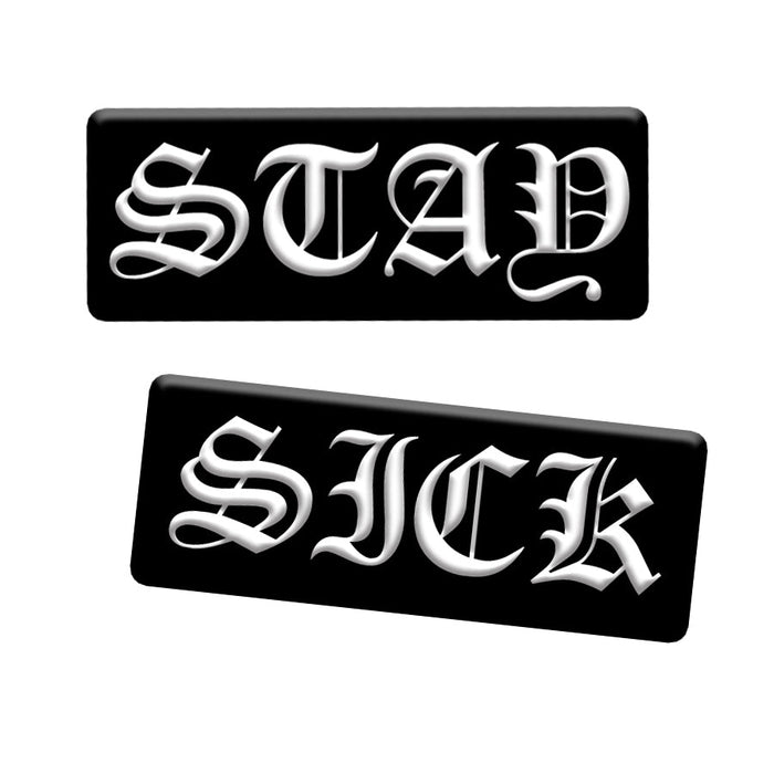 Stay Sick Clothing presents a pin set: black rectangular enamel pins with bold white Old English text—one reads STAY, the other SICK, both with 3D effect. A standout addition to any collection.