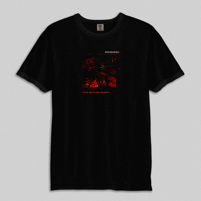Boundaries black t-shirt in soft ring-spun cotton, with a small red and black abstract chest graphic, BOUNDARIES above and YOUR BECOMING WARMTH below. Shown on a plain gray background.